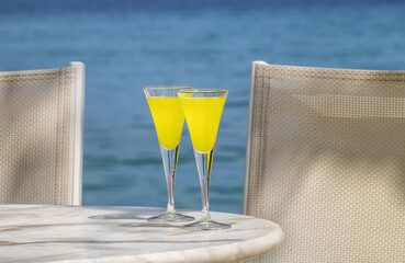 Zwei Gläser, gelber Aperitif, am Meer. Peloponnes, Griechenland  24038.jpg