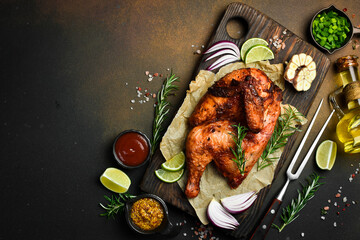 Grilled chicken with rosemary and spices on a wooden board. Traditional festive dish.