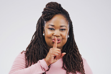 African woman, finger on lips and portrait in studio for secret news, privacy and gossip for...