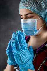 medical woman doctor or nurse with hands clasped in prayer isolated on black