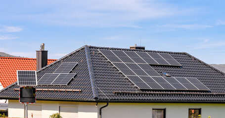 Solaranlage auf Walmdach eines Einfamilienhauses mit Verkehrsüberwachung im Vordergrund