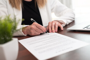 Hand of businesswoman signing a document  (Lorem ipsum text used)