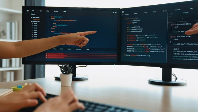 Slow motion back end software developer engineer for computer programming working together on debugging writing computing code, solving complex algorithms display on monitor in office. Burgeoning