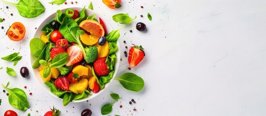 A healthy meal of fresh salad containing fruits and vegetables, displayed from a top perspective on a white background with room for text.