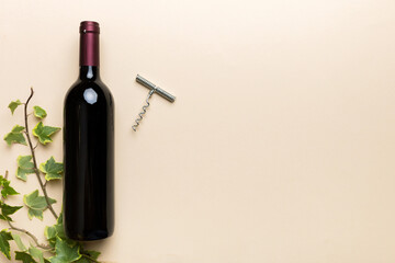 One Bottle of red wine with corkscrew on colored table. Flat lay, top view wth copy space