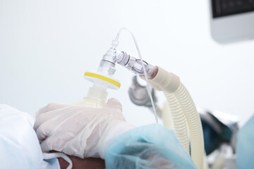Preparing the patient for surgery. Introduction to anesthesia. A breathing mask in the hands of a...