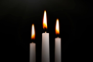 Funeral symbol with burning candle in darkness
