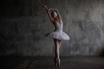 Ballerina in a white ballet costume dances the part of a swan.