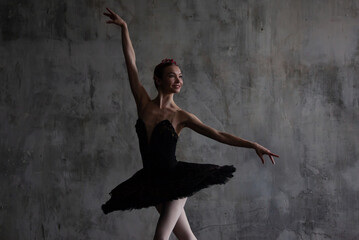 Ballerina in a black tutu performs the part of the black swan from the ballet Swan Lake.