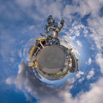 tallest hindu shiva statue in india on mountain near ocean on little planet in blue sky with evening clouds, transformation of spherical 360 panorama. Spherical abstract view with curvature of space.