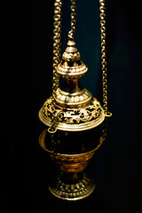 Golden candlestick on a black background. Hanging object