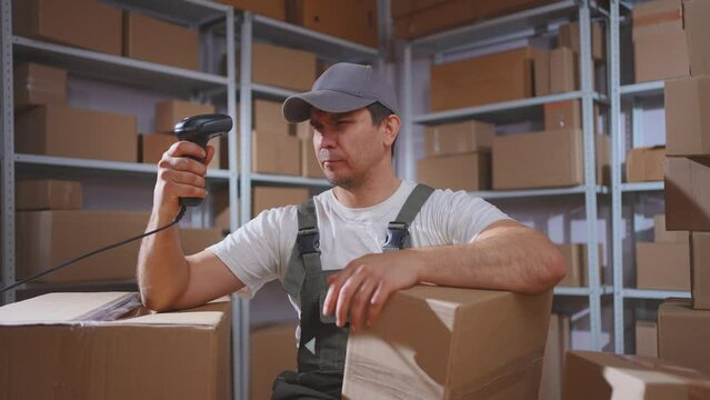 Lazy man in uniform loader procrastination ,scans boxes with barcode scanner
