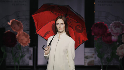 Fashion design female umbrella woman podium slow motion spotlight scene. Defile beautiful girl hold...
