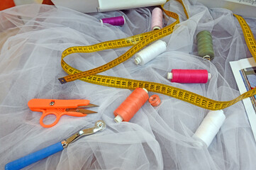 Accessories for sewing in the Schneider workshop. Tape measure, scissors, needles and threads.