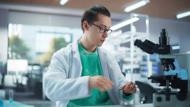 Medical Research Laboratory: Portrait of a Handsome Scientist Using Micropipette to Analyze Samples Under Microscope. Advanced Scientific Lab for Medicine, Biotechnology, Microbiology Development