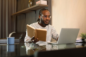 Young African American male entrepreneur using laptop working from home