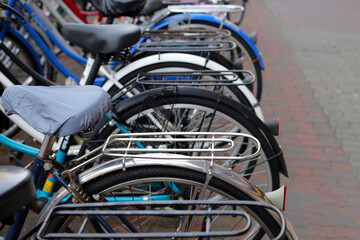 A group of bicycles lined up in a row on the sidewalk.