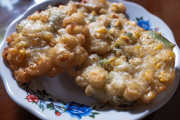Corn bakwan food in a white plate on the table, stock photo, traditional food, Indonesian food.