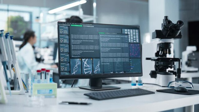 Desktop Display Standing on a Table in a Modern Science Laboratory. Computer Software Analyzing DNA Sequence and Generating Report for a Research Team, Anonymous Specialists Working in the Background