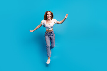Full length portrait of lovely girl jump fly empty space wear top isolated on blue color background