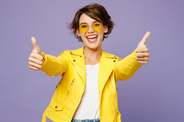 Young cheerful smiling woman wears yellow shirt white t-shirt casual clothes glasses showing thumb up like gesture isolated on plain pastel light purple background studio portrait. Lifestyle concept.