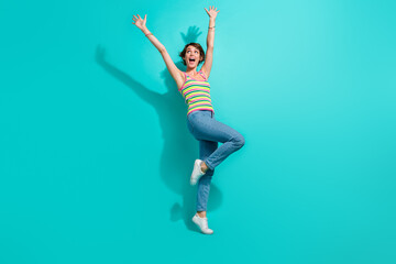 Fototapeta na wymiar Full body portrait of impressed cheerful lady raise arms empty space ad isolated on turquoise color background