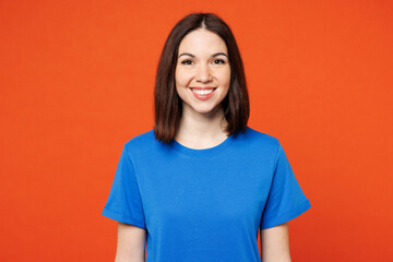 Young smiling happy cheerful satisfied woman she wear blue t-shirt casual clothes look camera with toothy smile isolated on plain red orange color wall background studio portrait. Lifestyle concept.