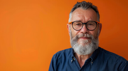 Obraz premium Close up Prtrait Of a business senior man against a orange studio background