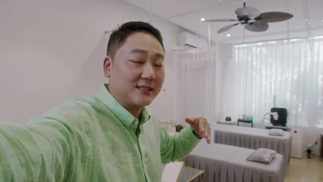 POV of Male Asian advertising specialist filming for spa salon website and looking at camera