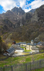 An Orthodox-Christian abbey located at the feet of some rocky mountains, near a beech woodland....