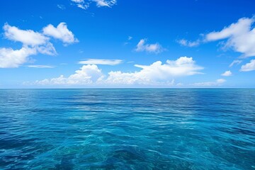 Obraz premium A photograph of a body of water with clouds hovering in the sky above, An endless blue ocean under a clear day sky, AI Generated