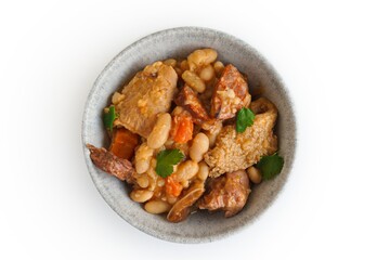 Tripas a Moda do Porto - pork tripe stew with white beans and smoked sausages in a bowl. Isolated flat lay