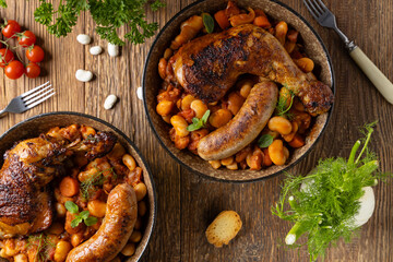A traditional French one-pot dish with beans, chicken and white sausage. Cassoulet. - obrazy, fototapety, plakaty