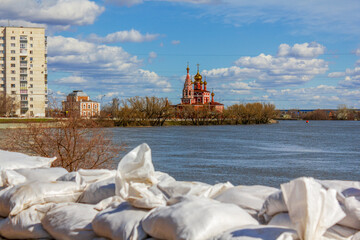 The flooding of the city embankment of the Tobol River with white sandbags piled in front for protection in Kurgan, Russia.