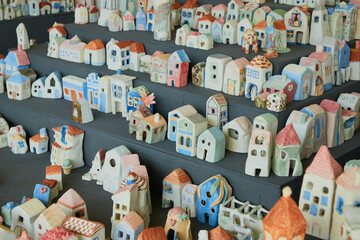 Assortment of hand-painted mini houses on shelves, in various colors and designs