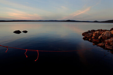 Red fishing boat rope at lake, Lapland Finland.