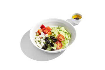 Greek salad with feta cheese, olives, and fresh vegetables isolated on white
