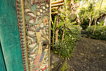 Bali style green wooden carved door in the traditional house of Ubud, Bali, Indonesia