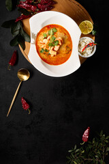 Authentic Thai Cuisine: Tom Yum Soup with Seafood and Rice on a Dark Table - 788216243