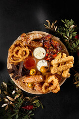 Variety of Beer Snacks on Dark Table - Toasts, Sausages, Fried Calamari, Onion Rings, Buffalo Wings - 788216839