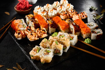 Diverse Set of Maki Sushi Rolls on a Stylish Slate Plate with Chopsticks