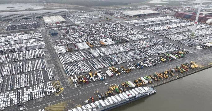 Aerial top down drone views of transportation of vehicles over seas from a sea port terminal, specifically the Zeebrugge, intermodal logistics, roll on roll off cargo, and loading unloading of new