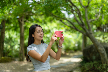Woman use of mobile phone to take photo at park