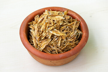 A pile of dried fish in an earthen pot. Locally In Bangladesh, It is called Kachki Shutki. It is also known as Ganges river sprat, Kachki, Kechki, Gura mach.