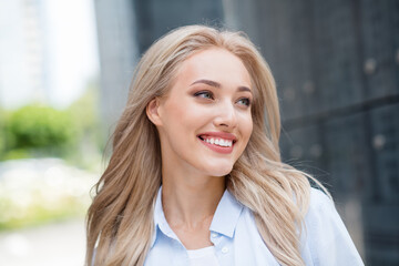 Portrait of positive pretty cute youngster girl blonde in big city walk alone summer outside