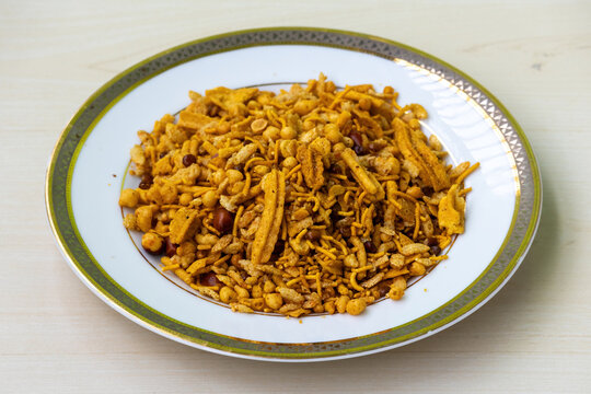 Rich and Spicy Snacks Bombay Mixed Chanachur on a white plate. Close-up view of Bangladeshi Crispy Food Bombay or Ruchi Classic Chanachur.