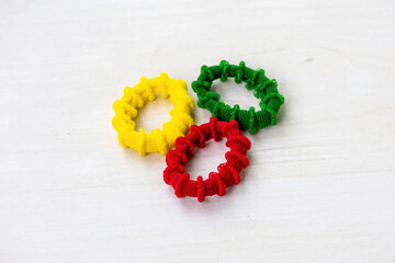 Colorful rubber bands isolated on wooden background. It is circular bands of fabric-covered elastic...