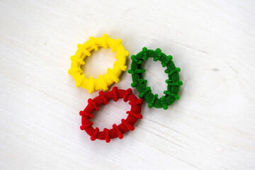 Colorful elastic rubber bands isolated on wooden background. It is circular bands of fabric-covered...