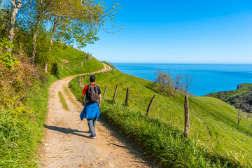 A male tourist trekking on the climb to the flysch of Zumaia, Gipuzkoa. Basque Country