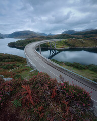 Curved bridge that crosses the lake in autumn. Kylesku Bridge crossing the Loch a Chairn Bhain in Sutherland, on the North Coast 500, Scotland